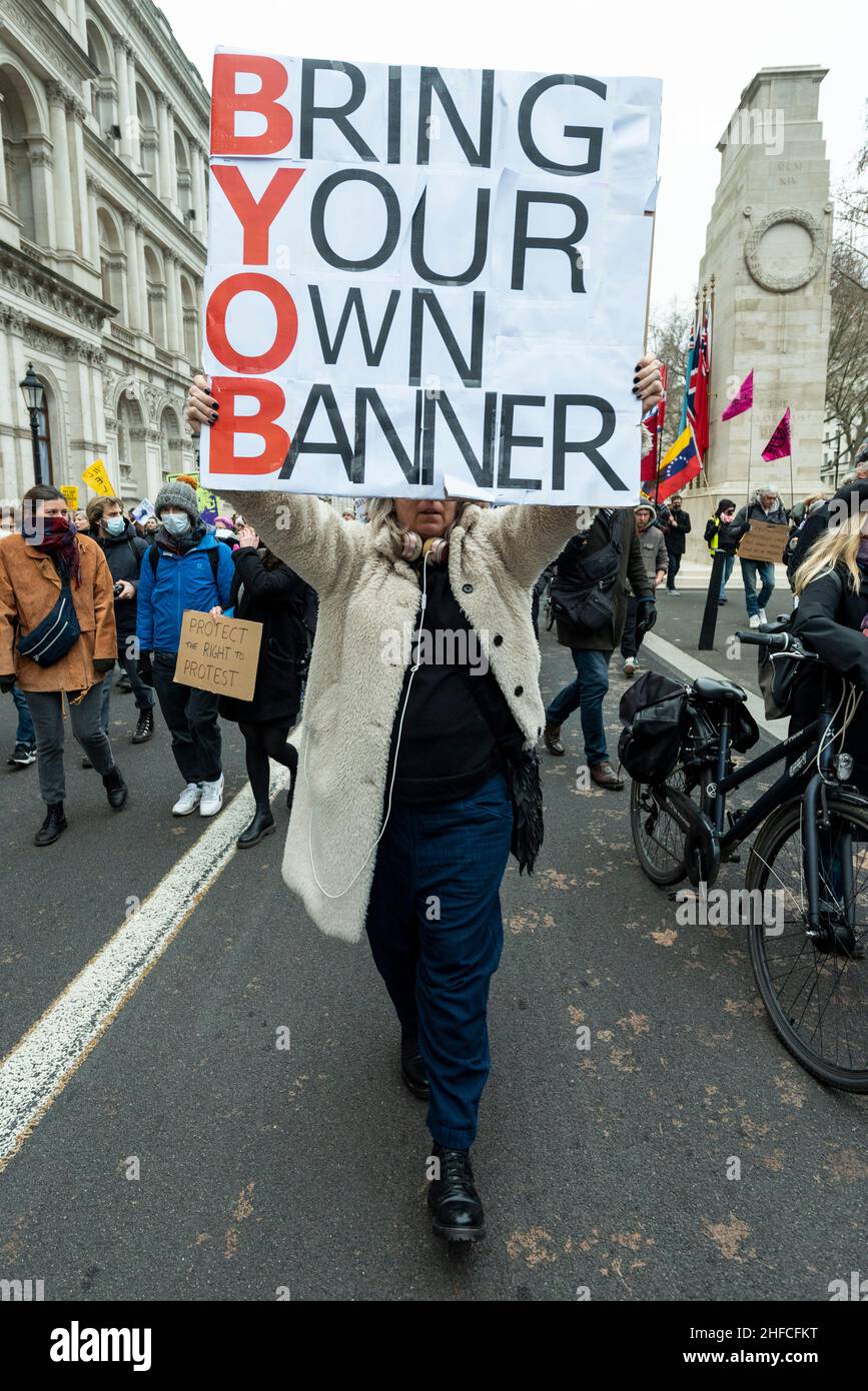 London, UK.  15 January 2022.  A woman outside Downing Street with a sign referencing Downing Street parties during a Kill the Bill protest in central London.  The protests were prompted by the Police, Crime, Sentencing and Courts Bill, which propose to give police in England and Wales more power to impose conditions on non-violent protests, including those which are deemed too noisy or a nuisance. Credit: Stephen Chung / Alamy Live News Stock Photo