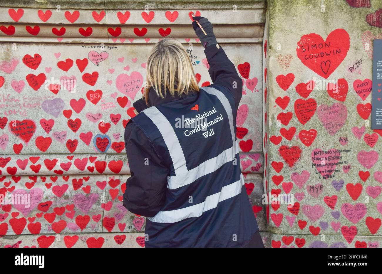 A volunteer paints red hearts on the National Covid Memorial Wall. Over 150,000 hearts have been painted to date on the wall outside St Thomas' Hospital opposite the Houses of Parliament, one for each life lost to COVID-19. (Photo by Vuk Valcic / SOPA Images/Sipa USA) Stock Photo