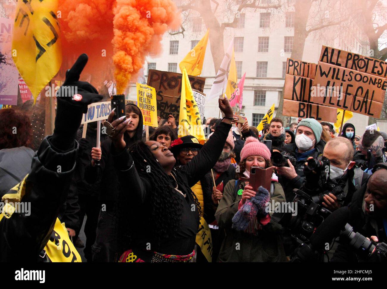 Protesters gather round an orange smoke flare on their march as part of the Kill the Bill movement. They hold signs that describe the new laws that are being passed. London, January 15th 2022. Anna Hatfield/ Pathos Stock Photo