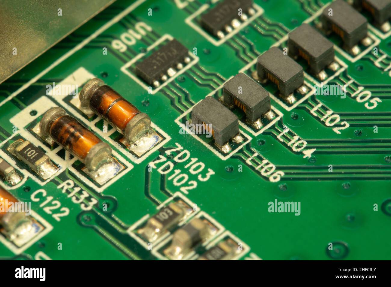 SMD inductors soldered on a green printed circuit board (PCB). Stock Photo