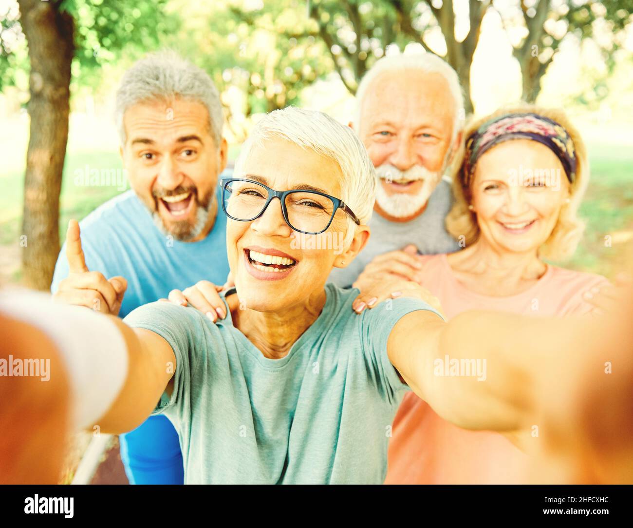 outdoor senior fitness woman man lifestyle active sport exercise healthy fit retirement selfie mobile phone Stock Photo