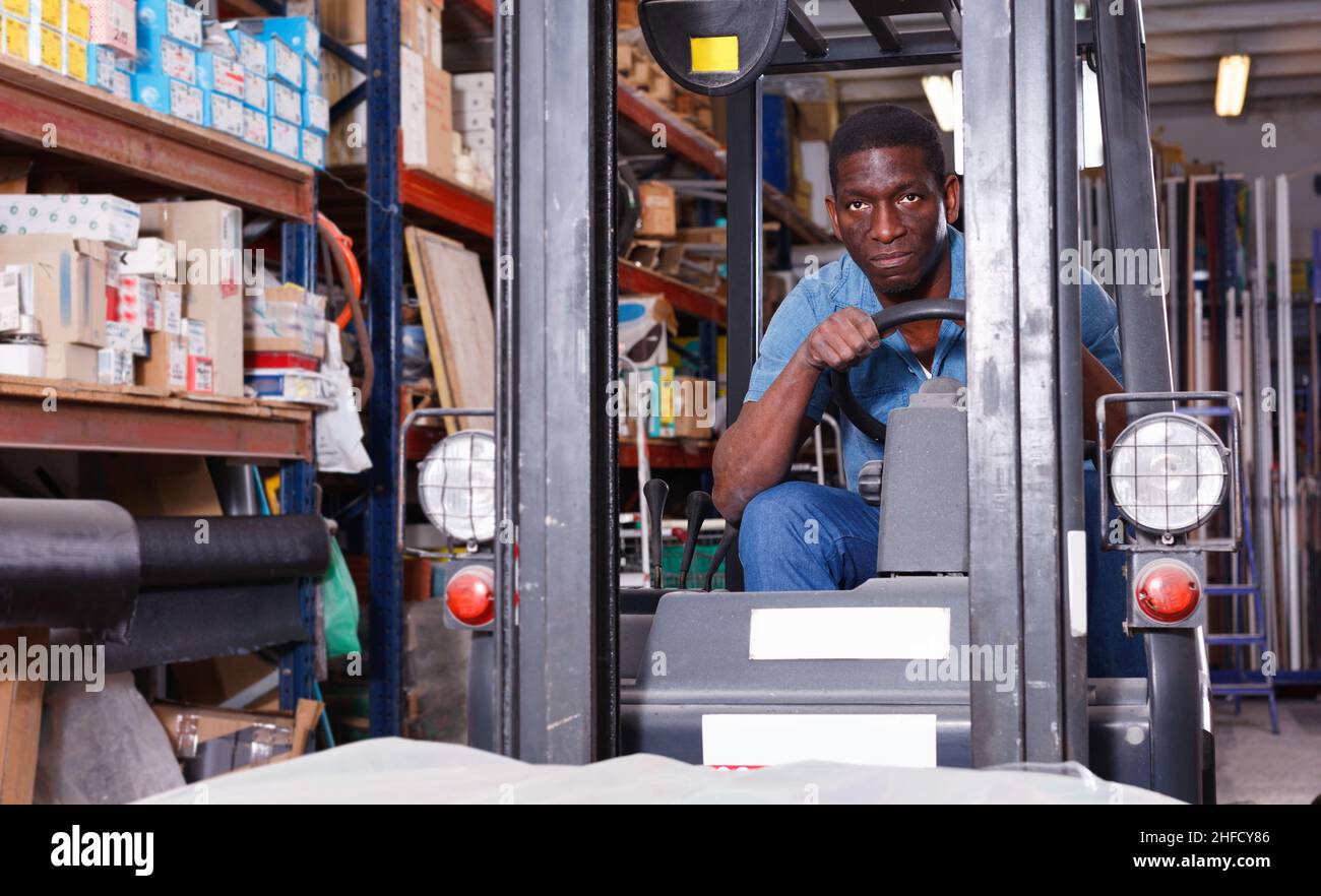 African American worker of building materials warehouse working on ...