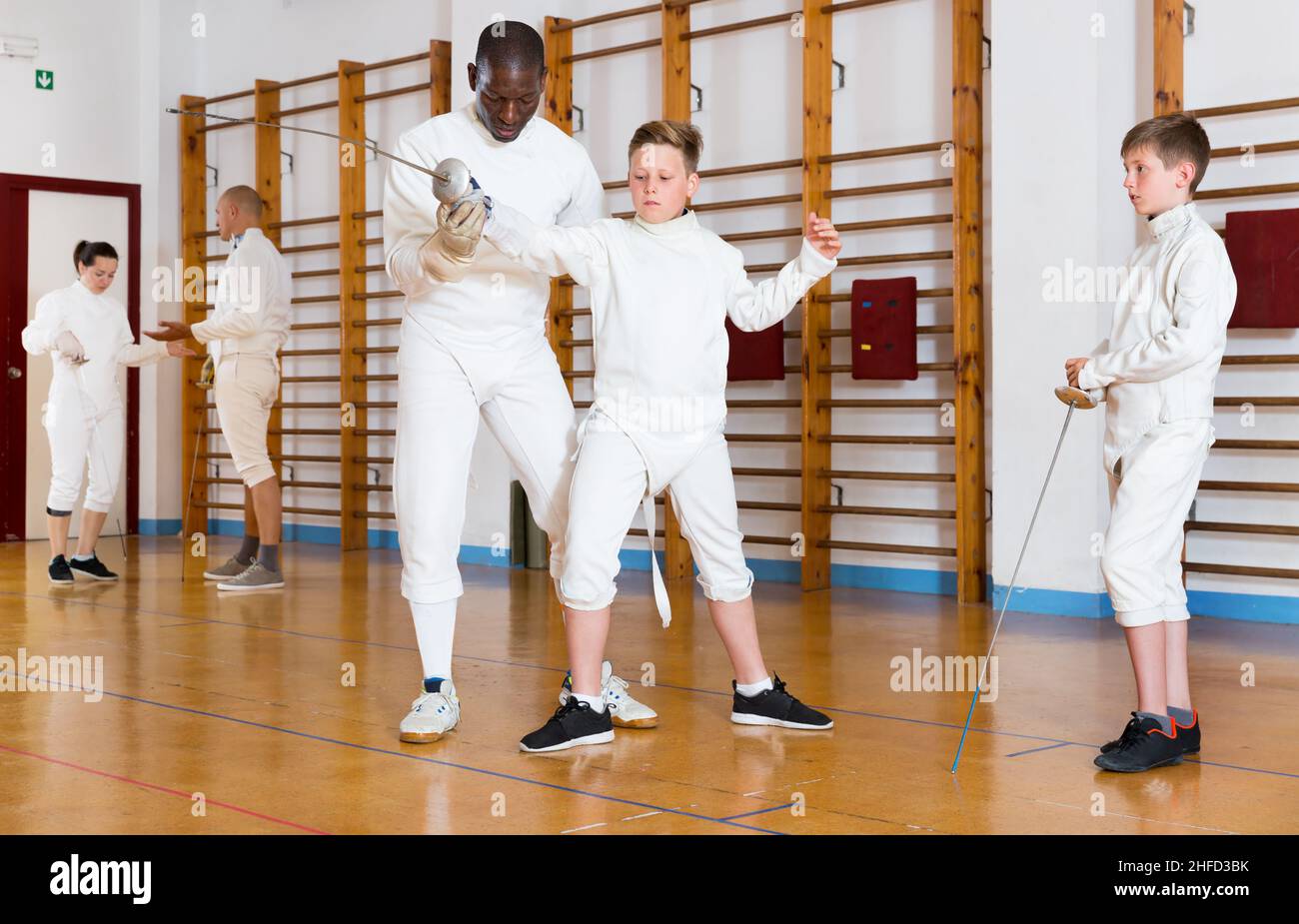 Fencing instructor with young fencers in training room Stock Photo Alamy