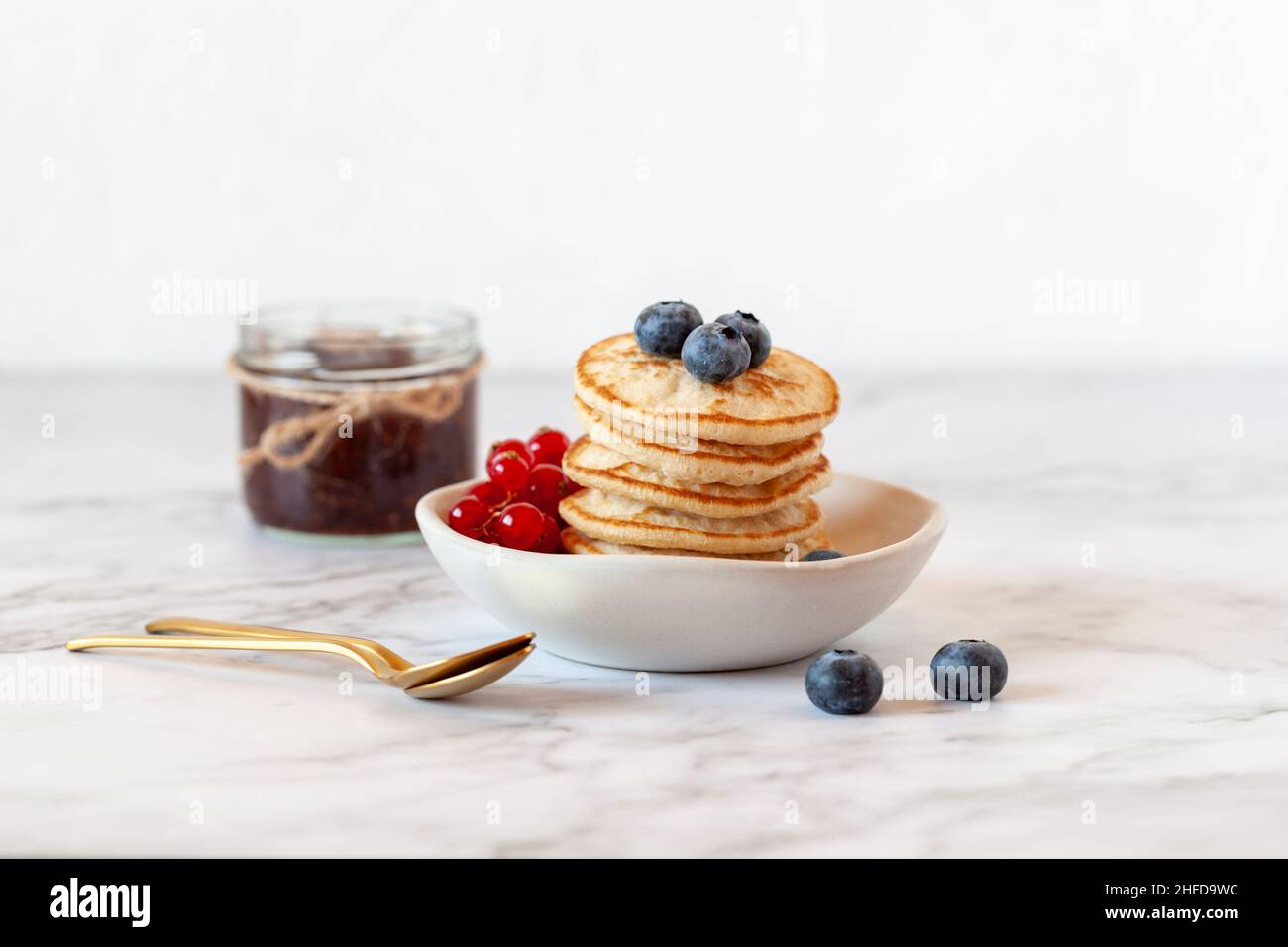stack of buckwheat flour gluten free pancakes decorated with blueberry and redcurrant, symbol of Shrove Tuesday, selective focus Stock Photo