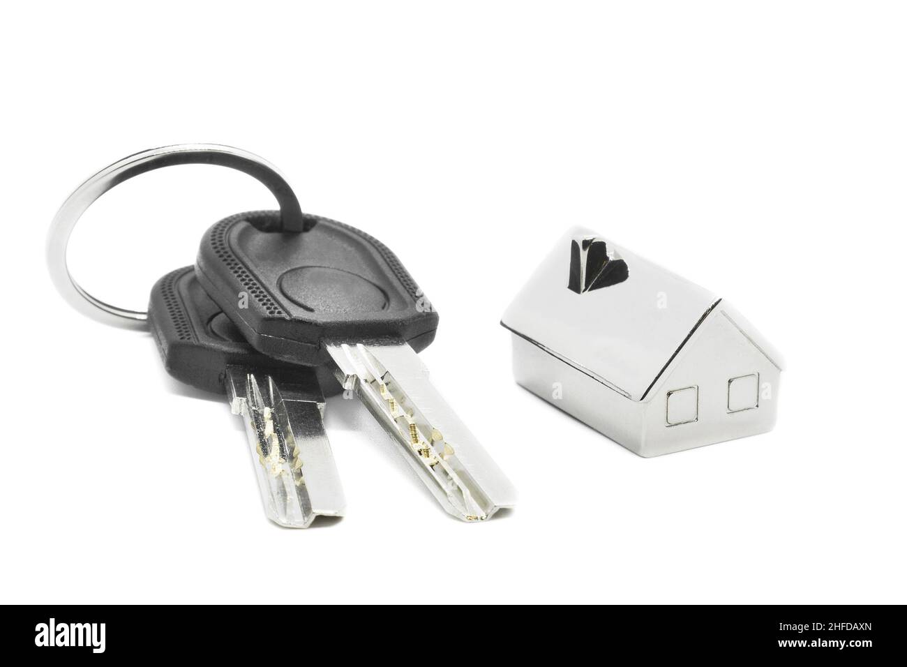 Two house keys and key-chain isolated on white background. Real estate purchase concept. Stock Photo