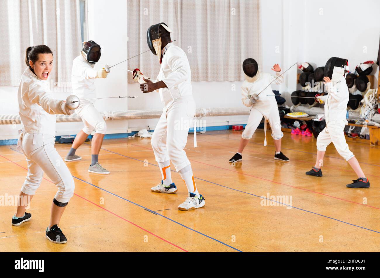 Young woman fencer practicing effective fencing techniques in training