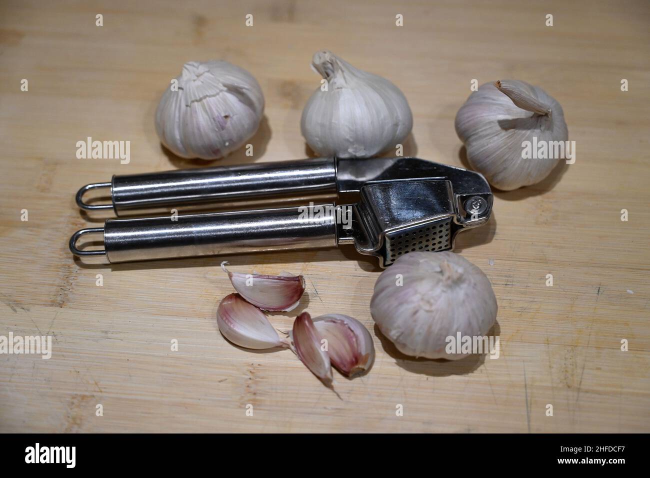 garlic bulbs and garlic crusher cooking and food preparation Stock