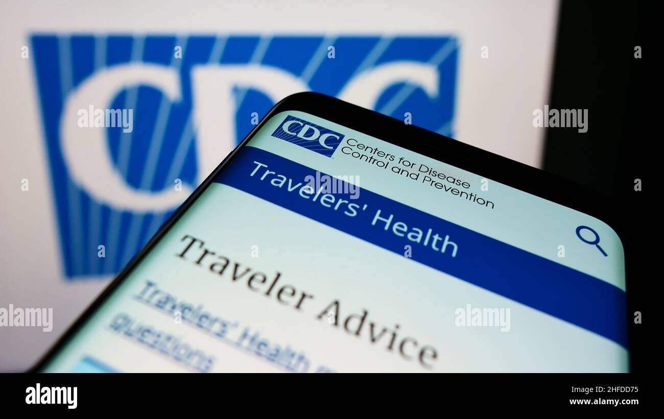 Mobile phone with webpage of Centers for Disease Control and Prevention (CDC) on screen in front of logo. Focus on top-left of phone display. Stock Photo