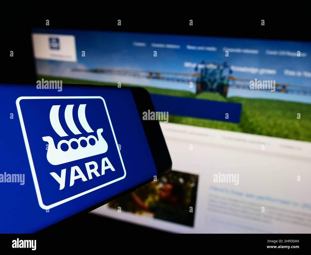 Smartphone with logo of Norwegian chemical company Yara International ASA on screen in front of website. Focus on center-right of phone display. Stock Photo
