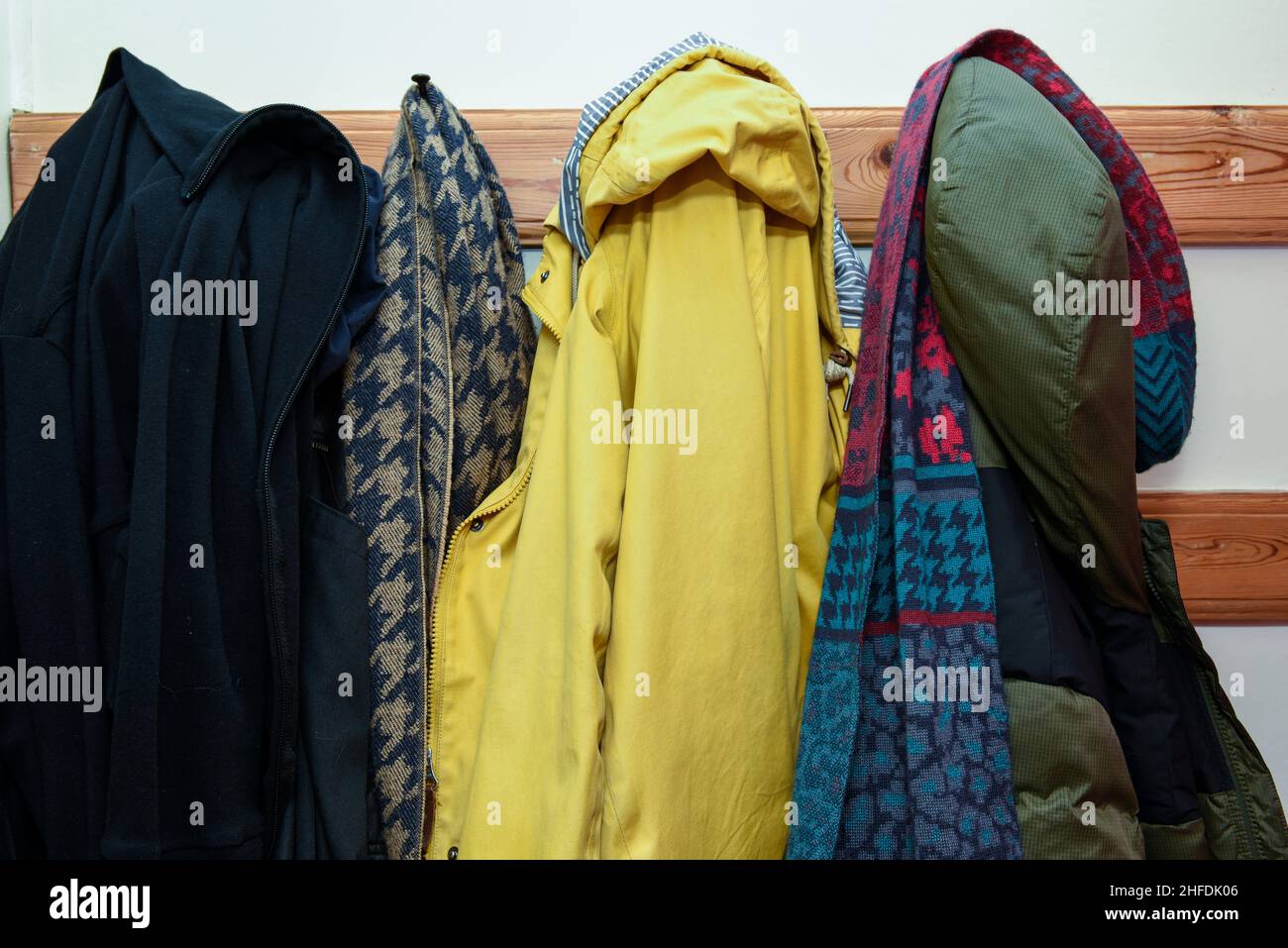 Coats and cold weather clothing in a a row in a family home Stock Photo