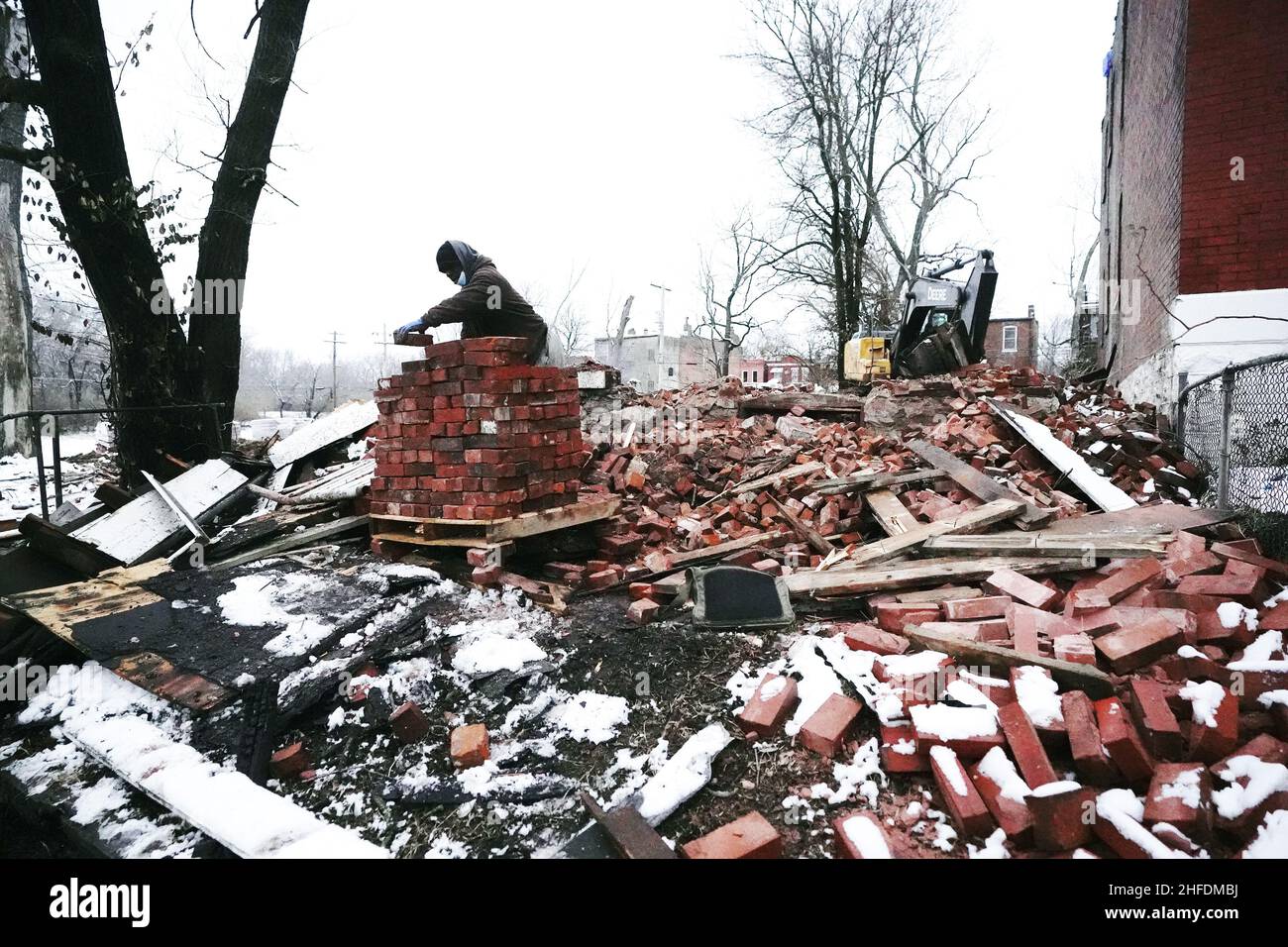 St. Louis, United States. 15th Jan, 2022. Workers stack bricks of what once was a vacant building in St. Louis on Saturday, January 15, 2022. On January 13, 2022, the building collapsed during a fire, killing one St. Louis firefighter and injuring several others. St. Louis reportedly has nearly 10 thousand vacant buildings becoming a hazard for firefighters, being a place to sleep for the many homeless of the area. Photo by Bill Greenblatt/UPI Credit: UPI/Alamy Live News Stock Photo