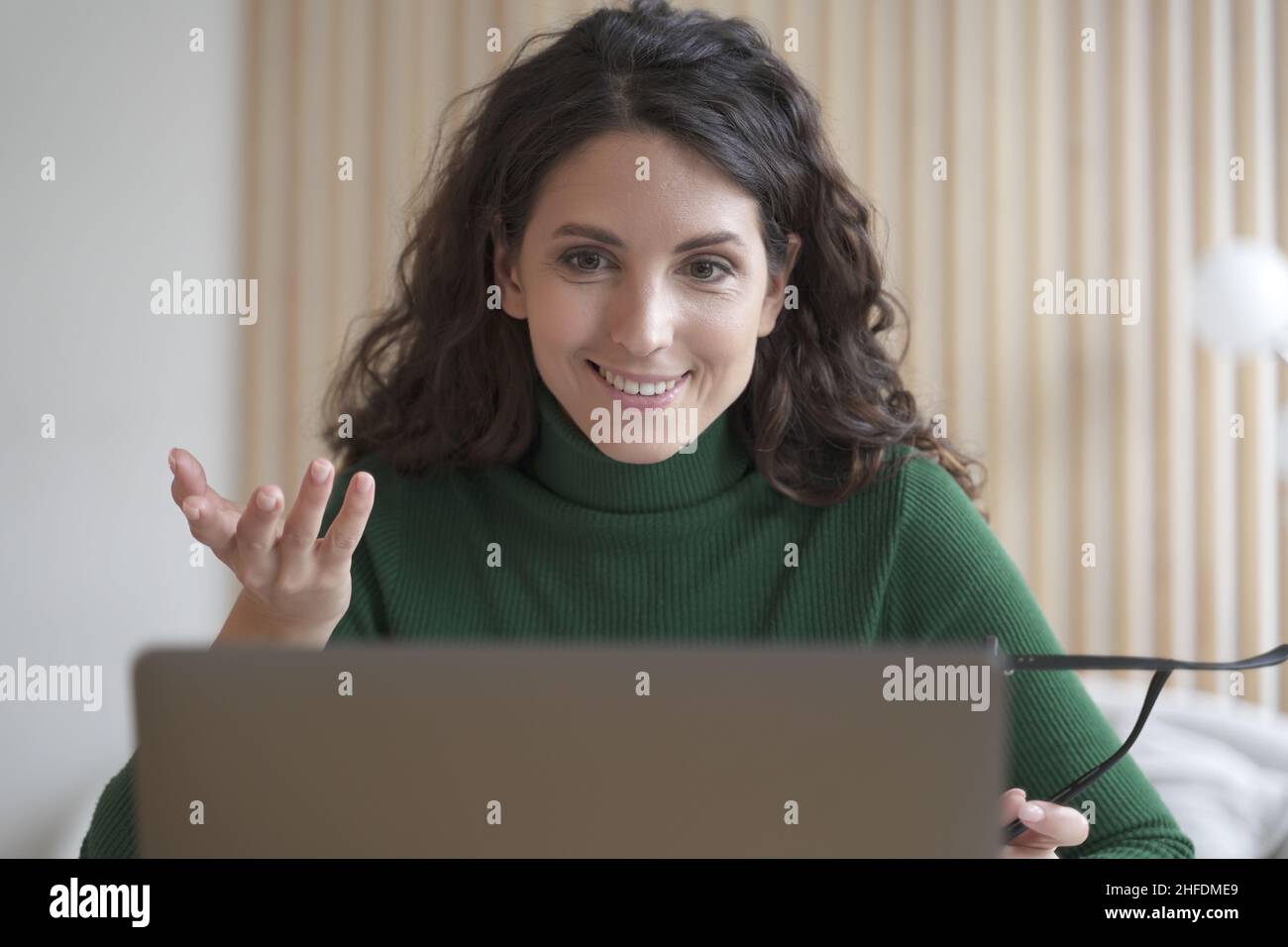 Smiling young Italian woman teacher tutor talks with students during online lesson on laptop Stock Photo