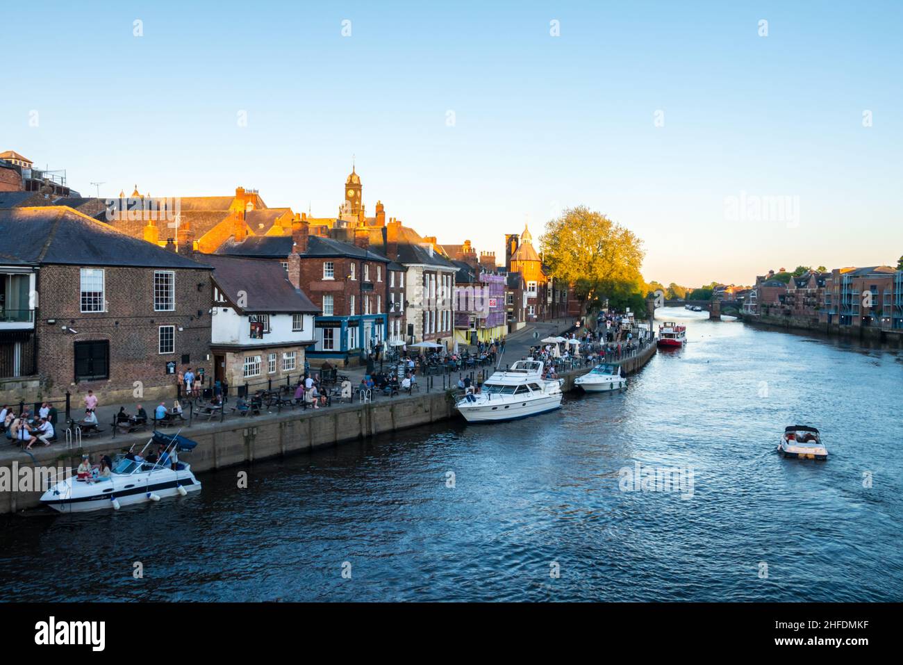 Boats on the River Ouse at York & People Relaxing in beer gardens along the banks of The Ouse Stock Photo