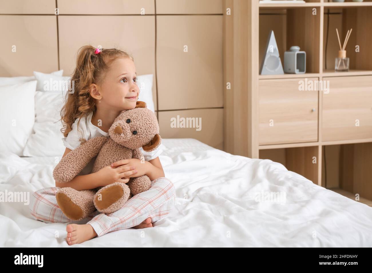 Adorable little girl with teddy bear in bedroom Stock Photo - Alamy
