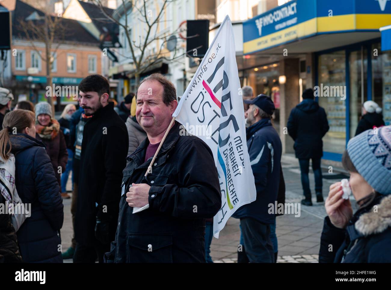 Amstetten, Austria - January 15 2022: Supporter of MFG Menschen Freiheit Grundrechte Party holding Flag at Protest or Demosntration against Mandatory Stock Photo