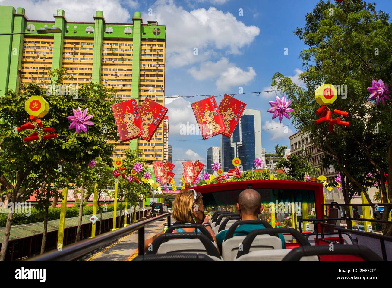Tourists sitting on open top bus checking out the Chinese New Year festival decoration. Singapore. Stock Photo