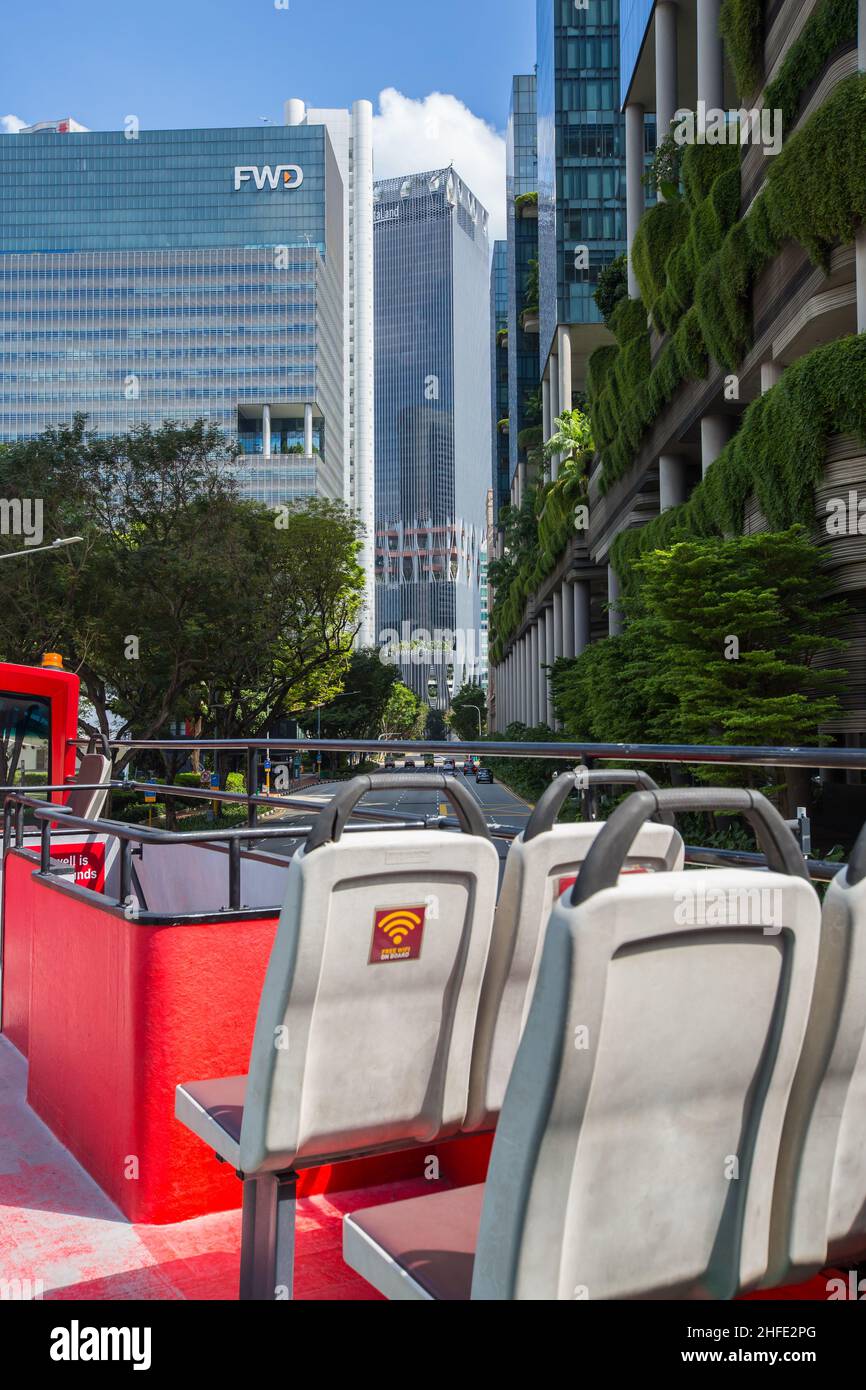 On-board an open top double deck bus turning into the business district, Singapore. Stock Photo