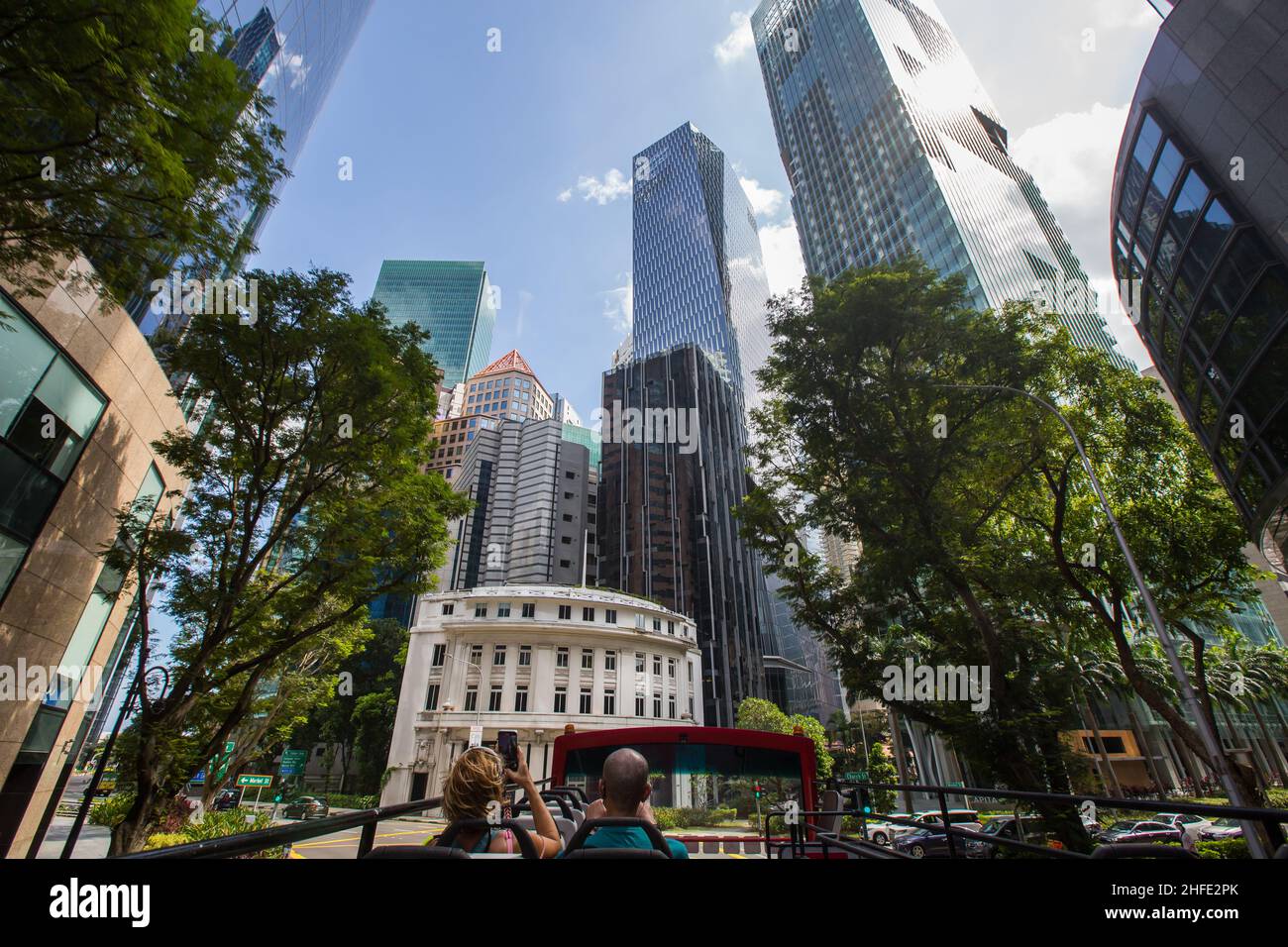 Visitors are touring on open top bus snapping pictures of Singapore Central Business district modern commercial architectures Stock Photo