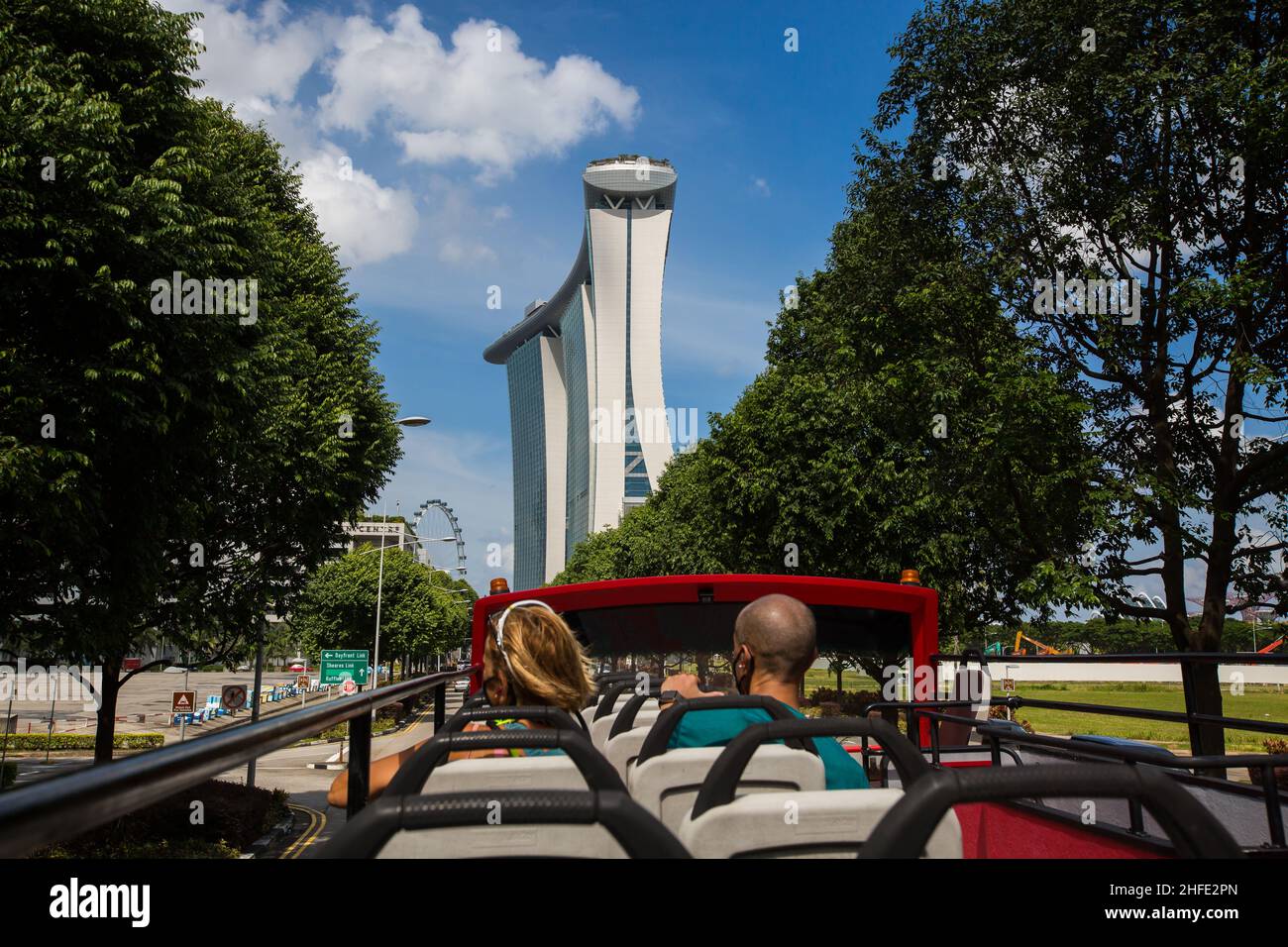 Foreigners travellers on open top bus tour seeing the lush green trees and the famous Marina Bay Sands in Singapore. Stock Photo