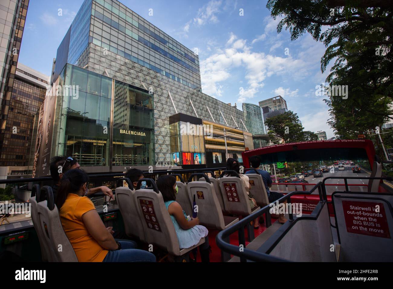 Open-top bus tour driving pass Orchard Road to view modern architecture, Singapore. Stock Photo