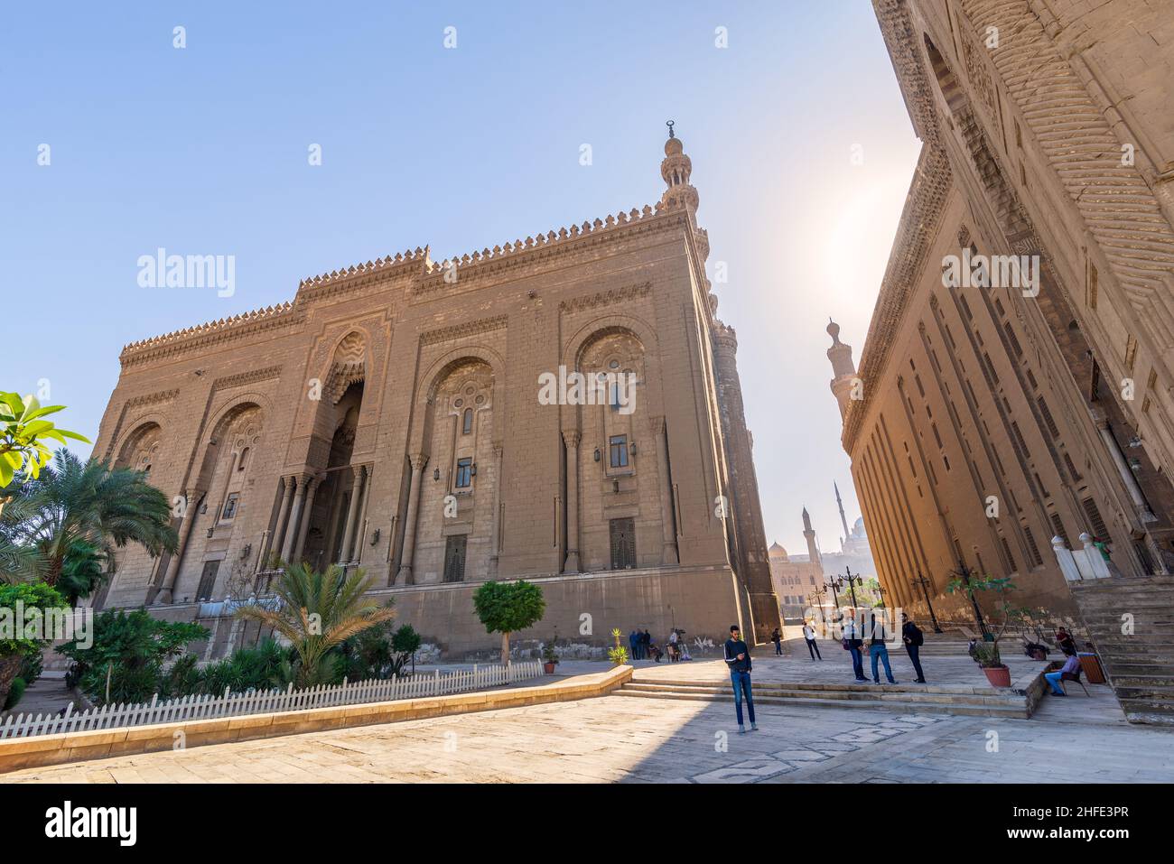 Cairo, Egypt - November 27 2021: Facade of Islamic Royal era Mosque of Al Rifai, with side view of Mamluk era Mosque and Madrassa of Sultan Hassan, with few visitors, Old Cairo Stock Photo