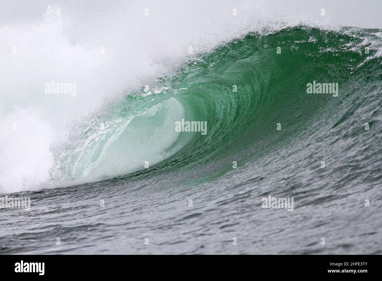 A large hollow curling tube wave at Airport Reef in Tuban, Bali in Indonesia. Stock Photo