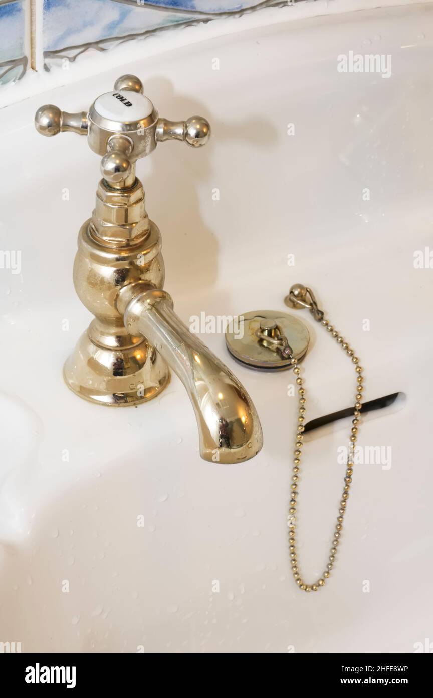New luxury hotel vintage brass gold plated pillar taps in ensuite bathroom at wash basin Stock