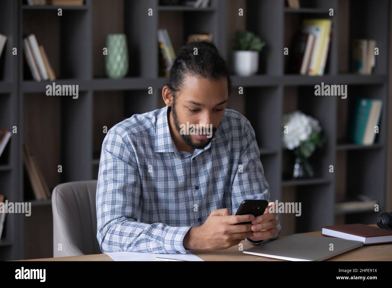 Focused busy millennial Black business man browsing internet on smartphone Stock Photo