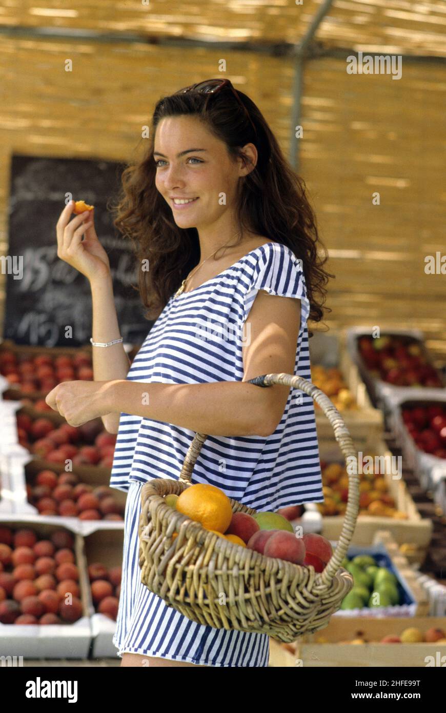 dark hair young woman happy face profil ray dressed shopping fruits market natural light Stock Photo