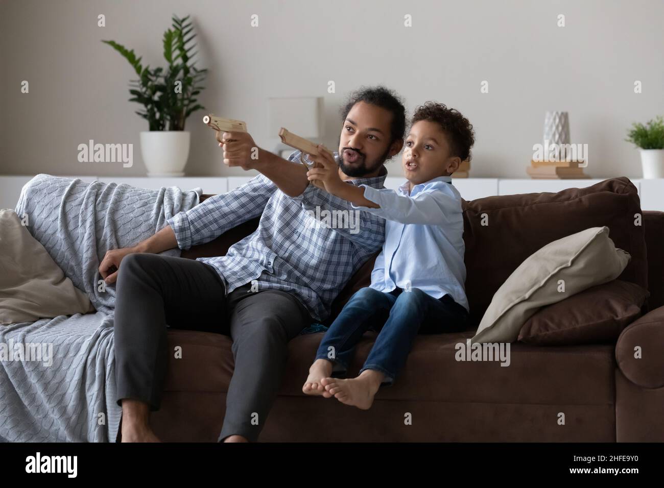Excited Afro American dad and son kid playing video game Stock Photo