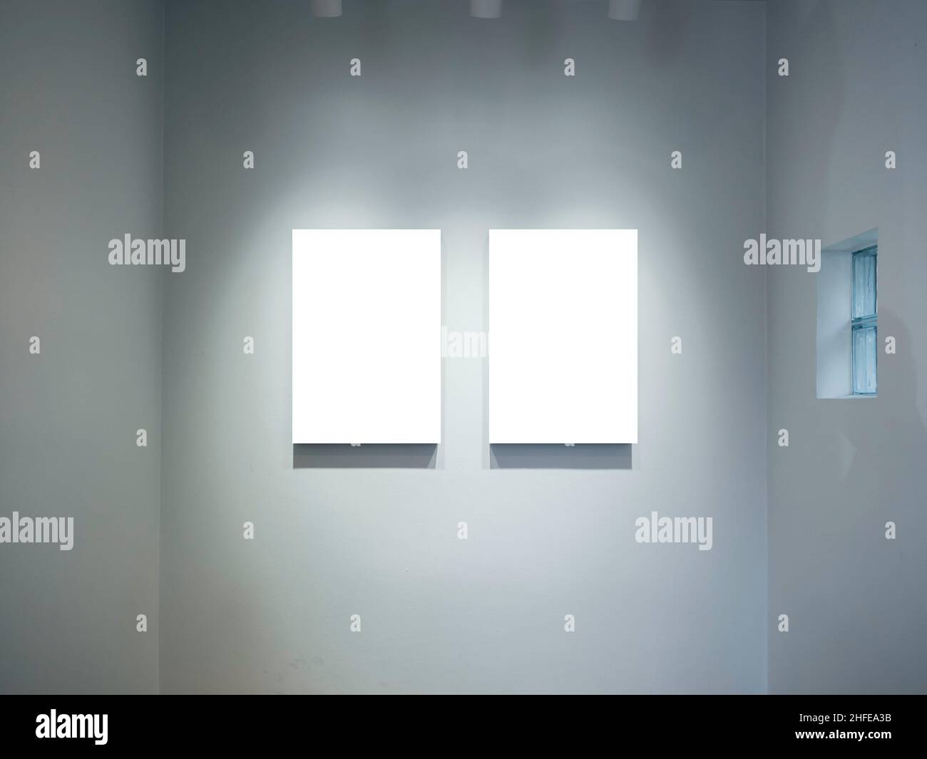 Two mockup vertical rectangle painting frames hanging on white wall
