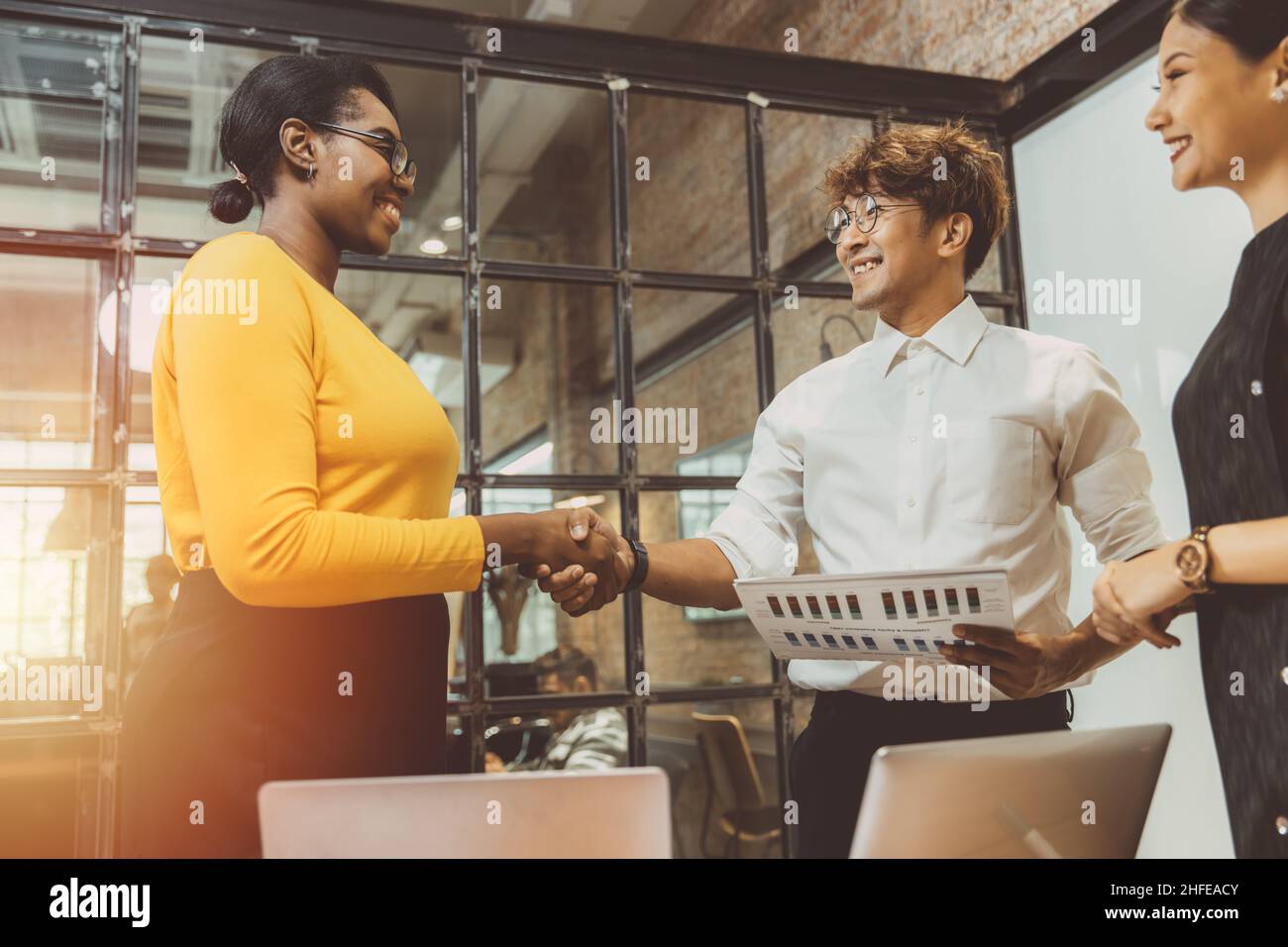 Black African business women hired hand shaking deal work with Asian boss enjoy working together concept. Stock Photo