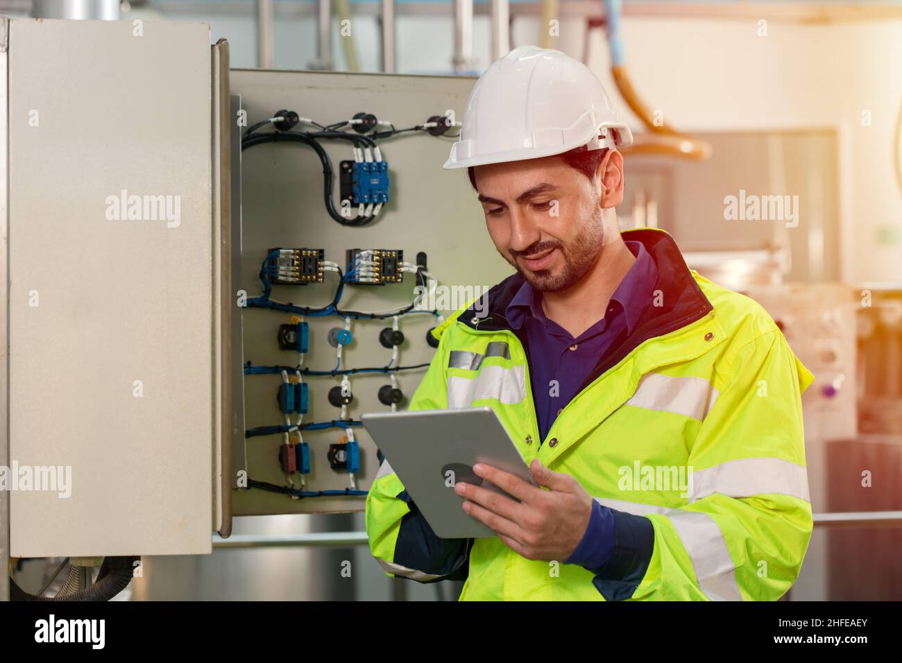 engineer worker working checking maintenance electricity fuse box in and power line in factory. Stock Photo