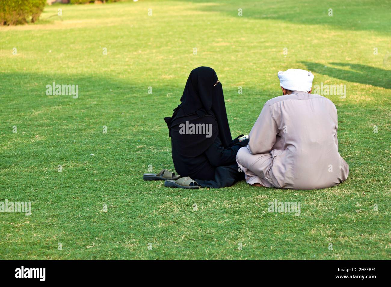 islamic woman in burka sitting on the green with her husband Stock ...