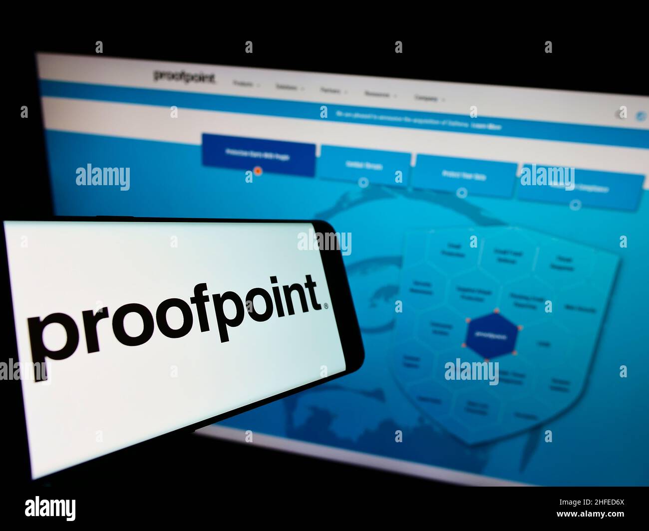 Cellphone with logo of American security software company Proofpoint Inc. on screen in front of website. Focus on center-right of phone display. Stock Photo