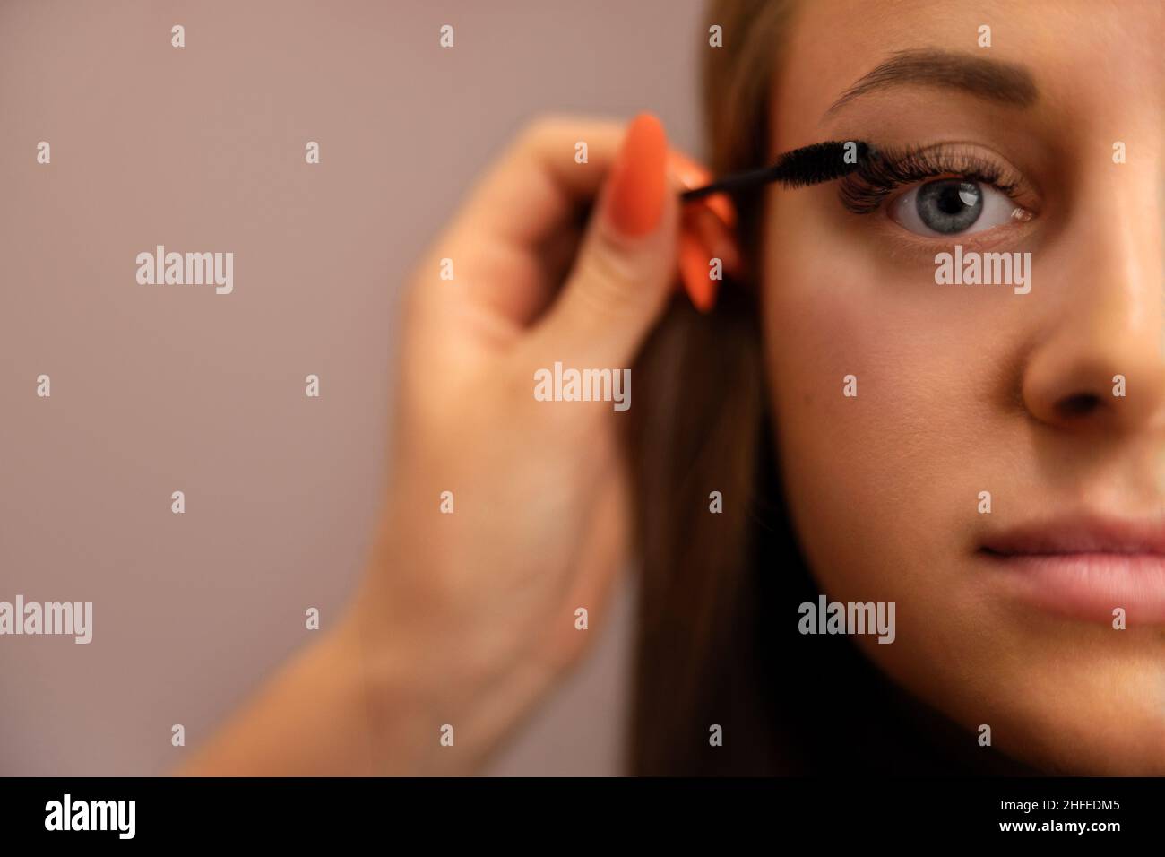 Portrait Of Woman With Cosmetologist Hand Using Mascara Stock Photo