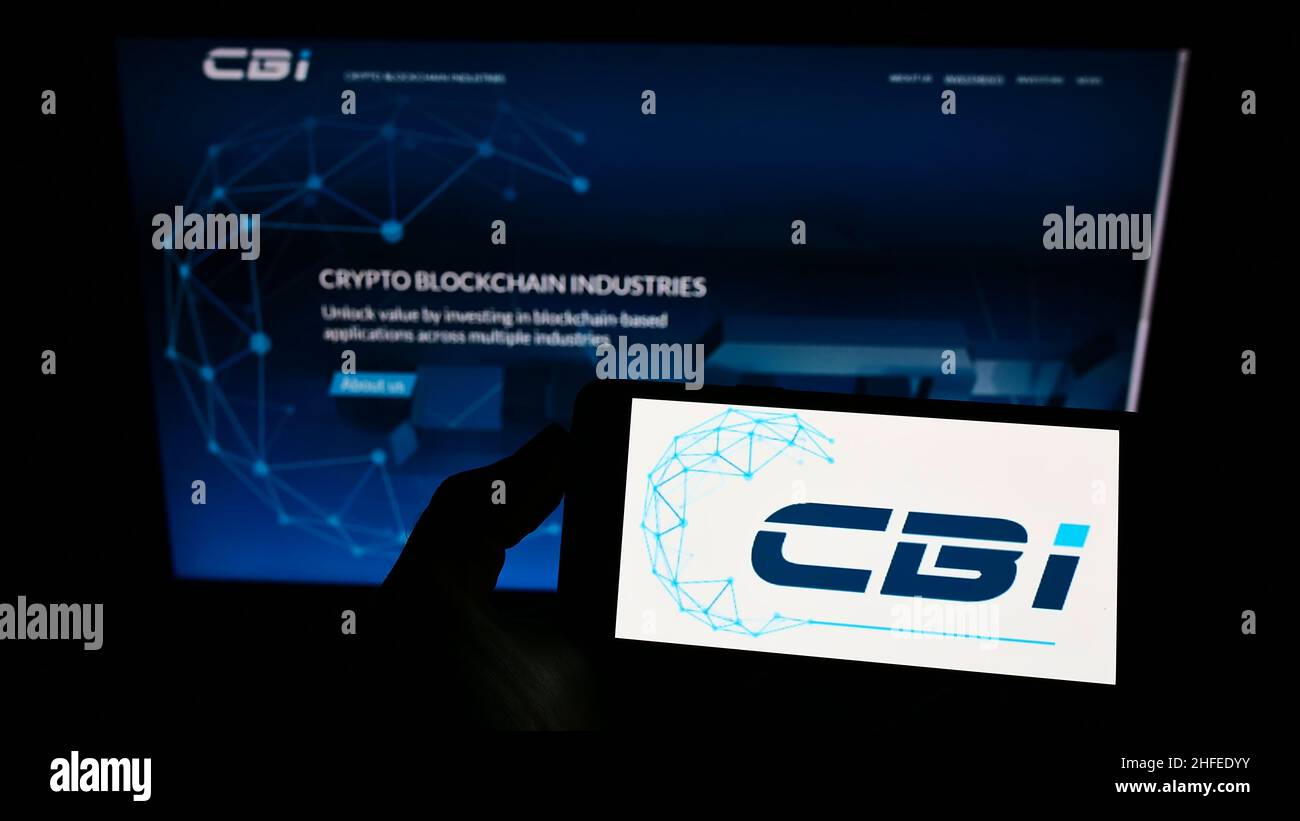 Person holding smartphone with logo of French company Crypto Blockchain  Industries (CBI) on screen in front of website. Focus on phone display  Stock Photo - Alamy