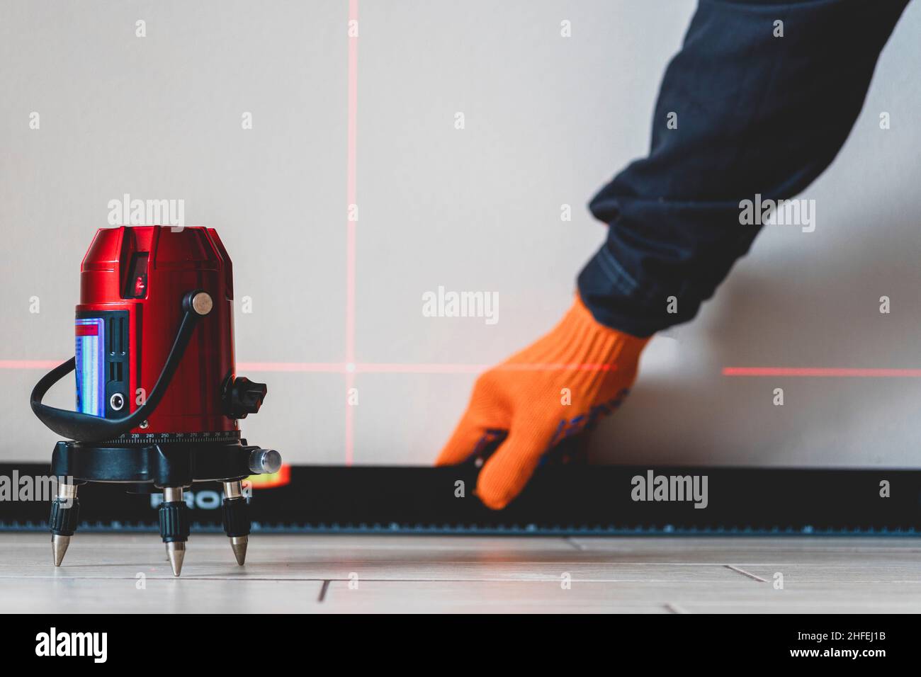 Worker and Bubble,laser level. lines on the wall. measuring with red