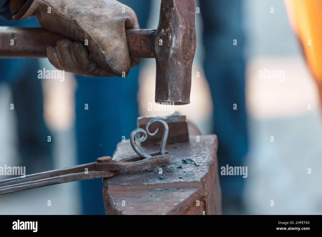 The blacksmith manually forging the molten metal on anvil Stock Photo ...