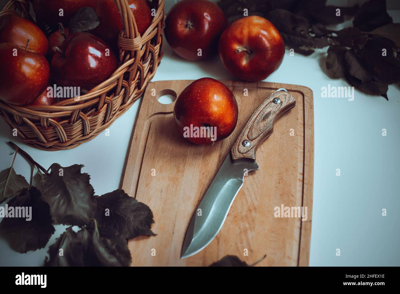 On a table there is a basket with scarlet ripe juicy apples, and next ...