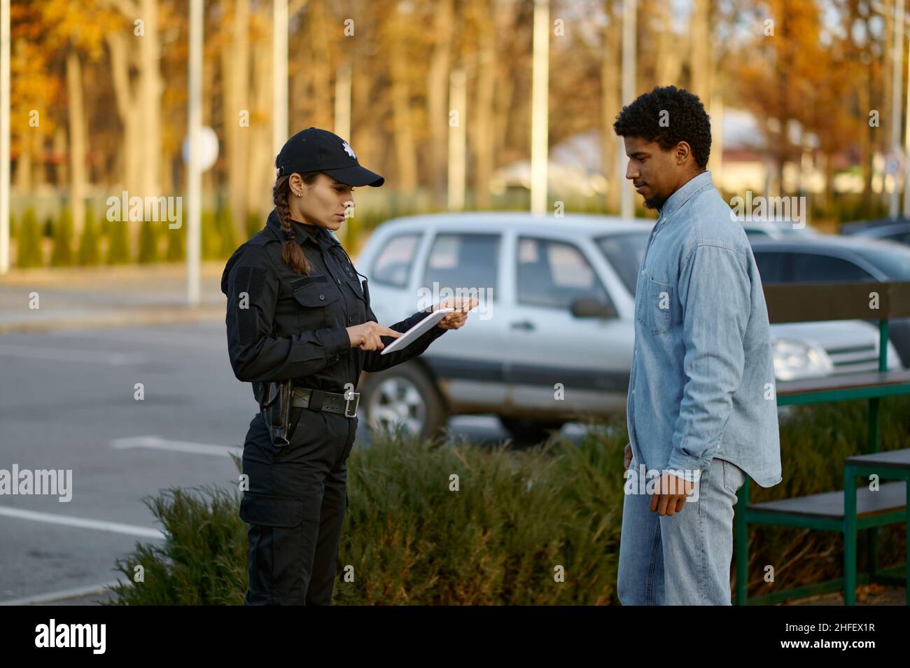 Female cop checking male passerby ID document Stock Photo