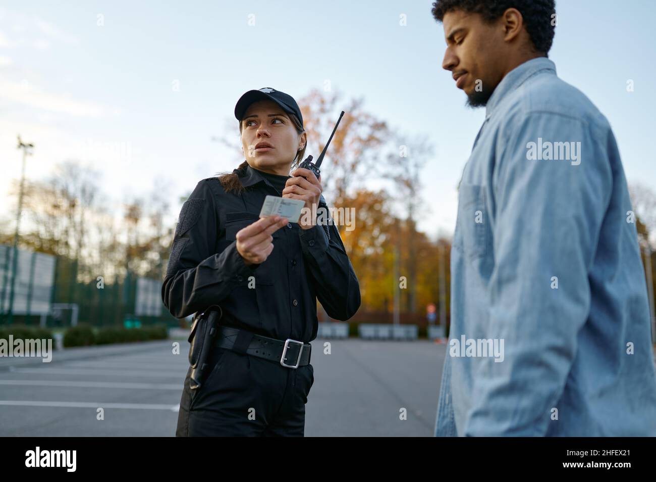 Female cop checking male passerby ID document Stock Photo