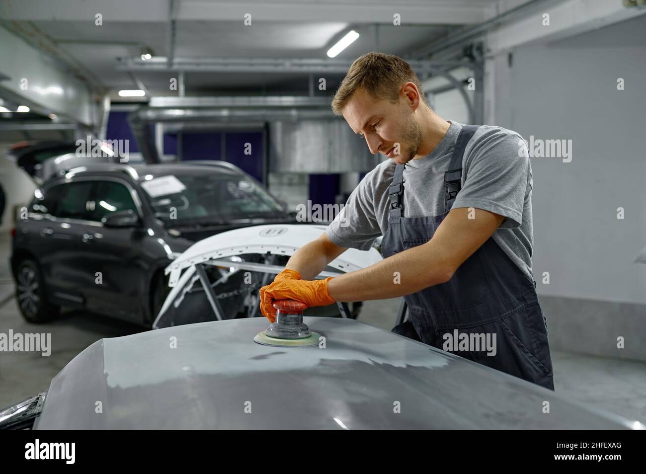 Repairman with sander removing old paint car Stock Photo Alamy