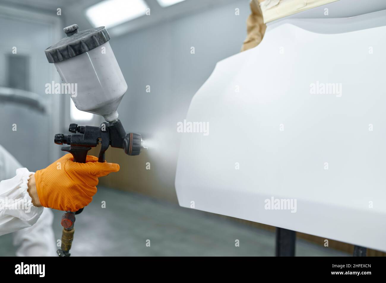 Technician in safety clothing spraying car paint Stock Photo
