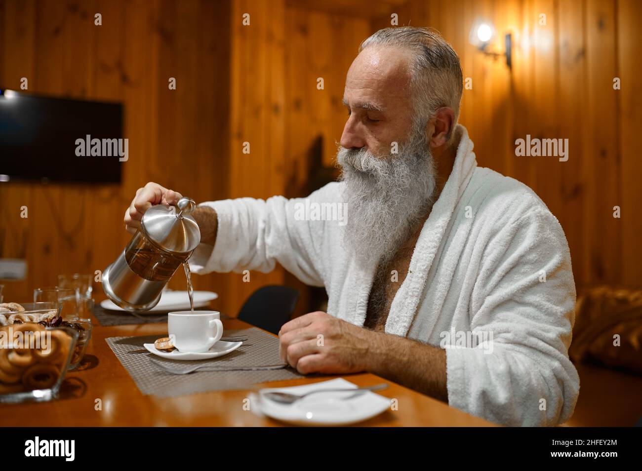 Man pouring tea during rest in sauna Stock Photo