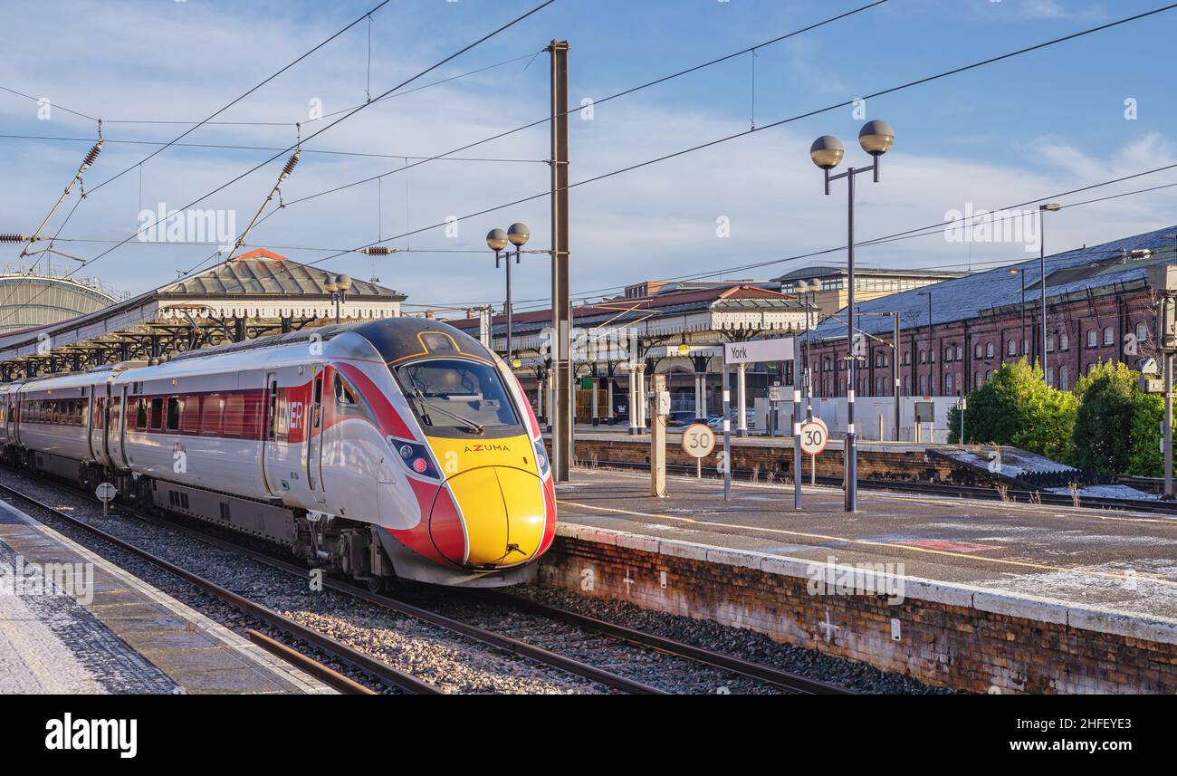 A train rests at a railway station platform with a light dusting of ...