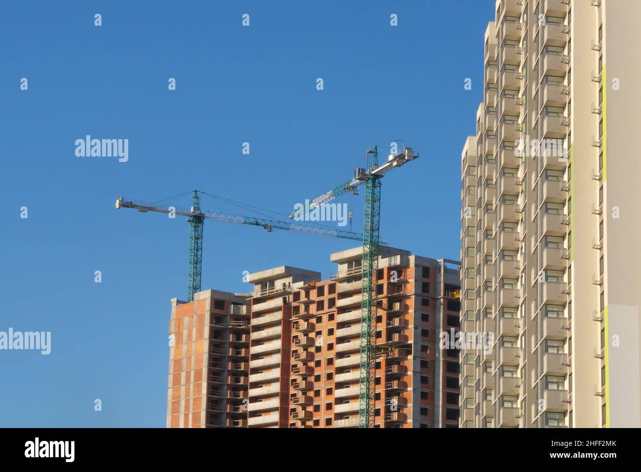 New building construction background clear blue sky. Multistory house. Mortgage. Tower cranes construction site building company property investment Stock Photo