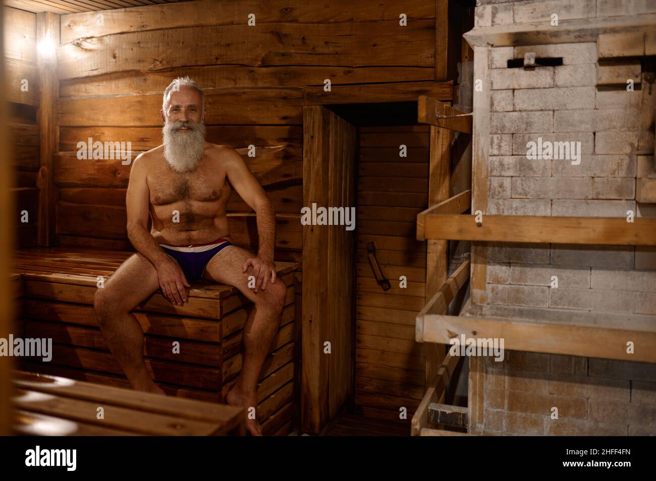 Grey-haired senior man rest at bath house Stock Photo