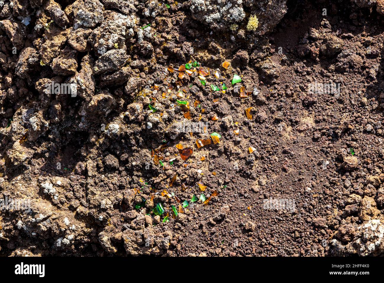 detail of volcanic area in Lanzarote,poluted by broken glass of a bottle Stock Photo