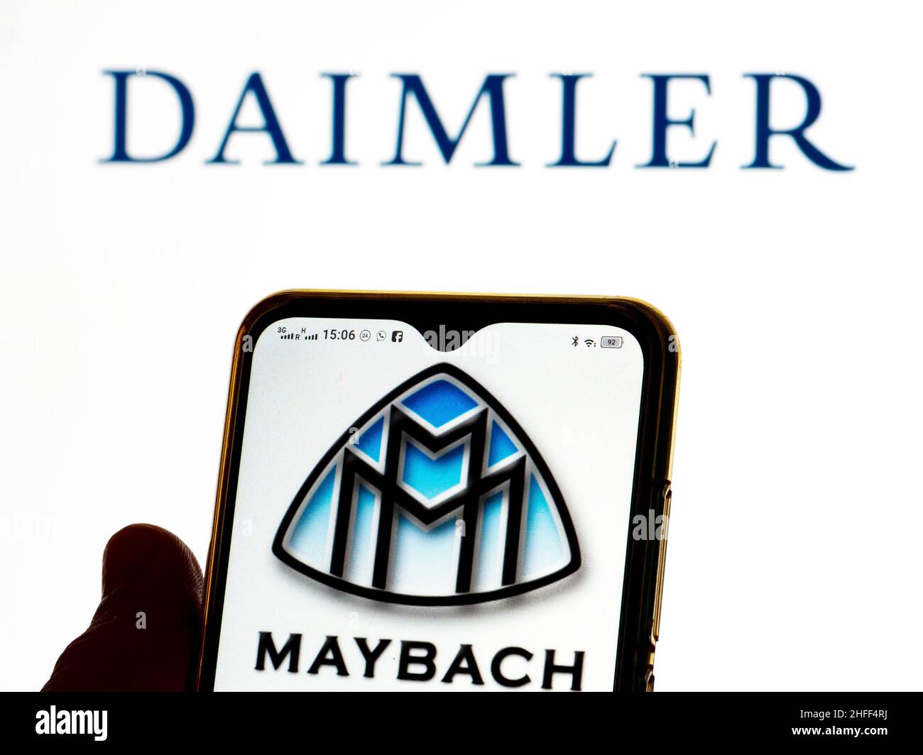 In this photo illustration, the Mercedes-Maybach logo is seen displayed on a smartphone screen with the Daimler AG logo in the background. Stock Photo